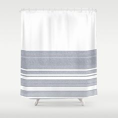 a white shower curtain with blue stripes on it