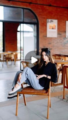 a woman sitting on top of a wooden chair