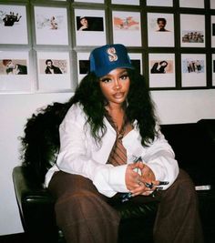 a woman sitting on top of a couch wearing a blue hat