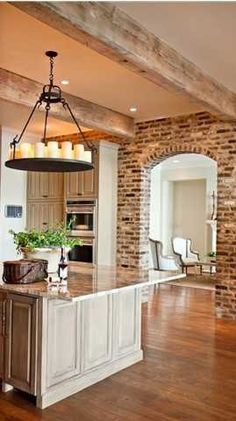 a large kitchen with an island in the middle and candles hanging from it's ceiling