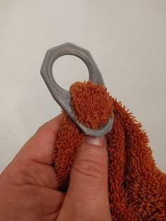 a hand holding a pair of scissors in front of a stuffed animal