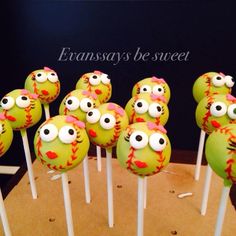 there are many green cake pops with eyes on them