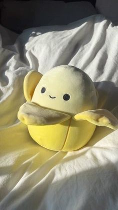 a yellow stuffed animal sitting on top of a bed