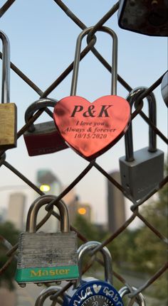 several padlocks attached to a chain link fence with heart shaped locks on them