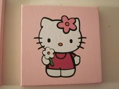 two pink canvases with hello kitty on them, one has a flower in its hand