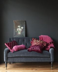 a couch with pillows and a painting on the wall