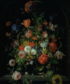 a vase filled with lots of different colored flowers