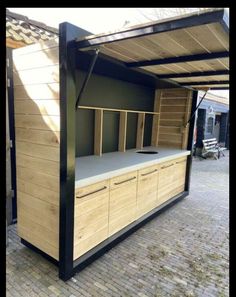 an outdoor kitchen made out of wood and metal with built in cupboards on the side