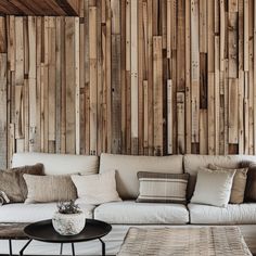 a living room with wooden walls and white couches in front of a coffee table