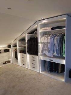 an attic closet with white drawers and shelves