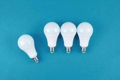 five white light bulbs on a blue background with one bulb turned off and the other turned down