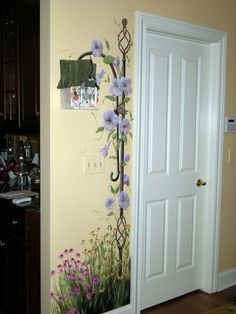 the door is open and there are flowers painted on the wall next to the doorway