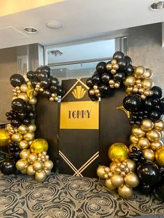 black, gold and white balloons are arranged in the shape of an army emblem on display