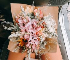 a bouquet of flowers sitting on top of a piece of paper next to a wallet