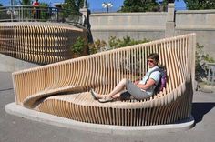 a woman is sitting on a wooden bench