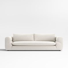 a white couch sitting on top of a white floor