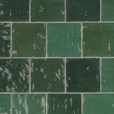 a green brick wall that has been painted with white paint and is being used as a background