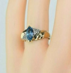 Vintage 14K Yellow gold Blue Topaz Diamond Accent Ring, medium blue central marquise cut 5x10mm faceted stone, white gold set, 2 accent diamonds bypass design, 3/8 inch across, Ring size 6.75, Circa 1965, 3.5 grams. SKU # BB271R09 Most rings are sizable for a small fee. If the ring you are considering is the incorrect size contact us for a quote. This listing contains photographs of the actual item you will receive. Our items are in excellent condition with little or no signs of wear and many ar Blue Marquise Diamond Ring With Diamond Cut, Blue Diamond Cut Marquise Ring, Blue Marquise Ring For Formal Occasions, Blue Topaz Ring With Marquise Cut Center Stone, Blue Marquise Cut Topaz Ring With Center Stone, Blue Marquise Cut Jewelry With Diamond Accents, Blue Diamond Marquise Ring With Accents, Blue Topaz Ring With Marquise Cut And Accent Stones, Blue Marquise Diamond Ring With Accents