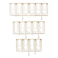 three gold metal wall shelves with hanging hooks