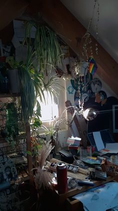 a cluttered desk in an attic with lots of clutter