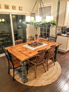 a dining room table with chairs and a rug on the floor in front of it