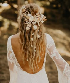 the back of a woman's head with long hair and flowers in her hair