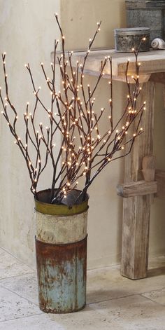 a potted plant with lights in it sitting on the floor next to a table