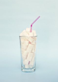 a glass filled with marshmallows and a pink straw