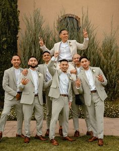 a group of men standing next to each other in front of a building with one man on his shoulders