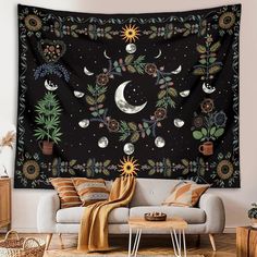 a living room with a large tapestry hanging on the wall and various plants around it