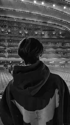 black and white photograph of a woman in an empty stadium looking out at the stands