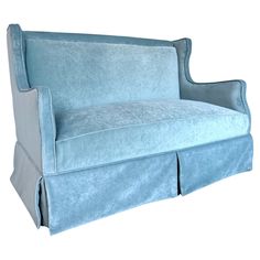 a light blue couch with pleated skirting on the armrests and back