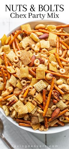 a bowl full of nuts and bolts party mix with pretzels, cheetos, and crackers