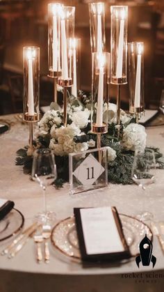 the table is set with candles, flowers and menus for an elegant wedding reception