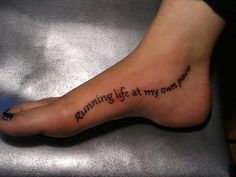 a person has a tattoo on their foot that reads running life at my own pace