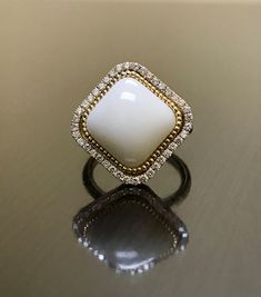 a white and gold ring sitting on top of a table