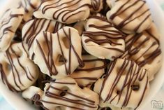 a bowl filled with chocolate covered donuts on top of a table