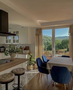 a kitchen and dining room area with an open door to the outside, overlooking mountains