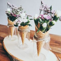 three ice cream cones with flowers in them