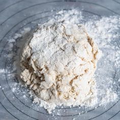 a ball of dough sitting on top of a wire rack in the middle of flour