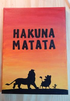 a painting with the words hakuna matata and two lions in front of an orange sunset