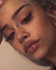 a close up of a woman with piercings on her nose