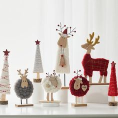 a group of christmas decorations sitting on top of a white table next to each other