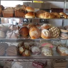 an assortment of breads on display in a bakery