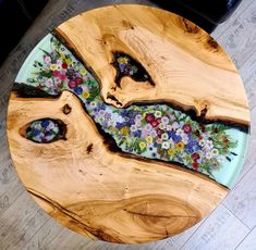 a wooden table with flowers painted on the top and one piece of wood in the middle