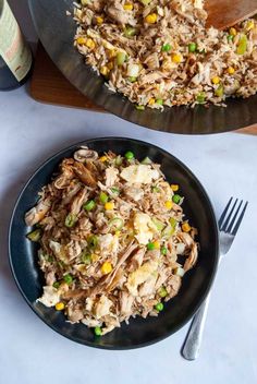 a plate full of rice and vegetables next to a bottle of wine