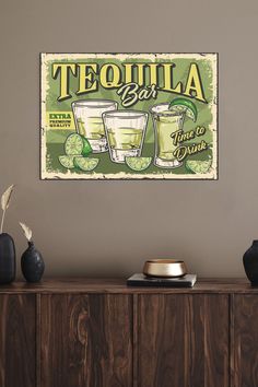 there is a sign on the wall that says tequila bar with two glasses of limeade