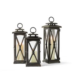 two lanterns with candles in them sitting next to each other