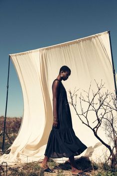 a woman standing in front of a white curtain