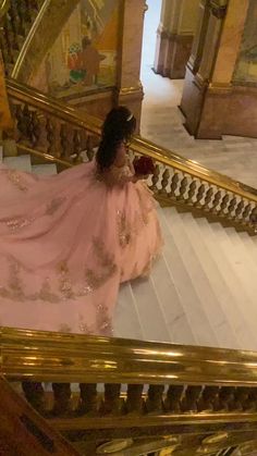 a woman in a pink dress is sitting on the stairs